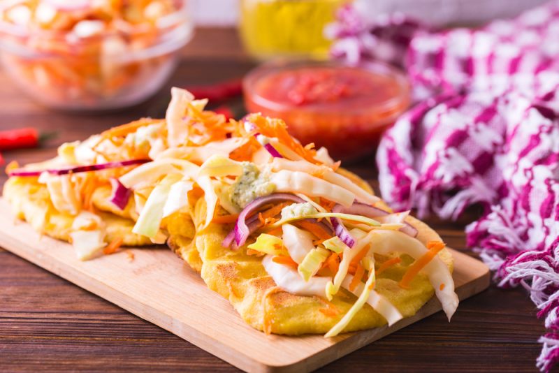 corn flour tortillas with cheese and beans inside and vegetable salad and chili tomato sauce