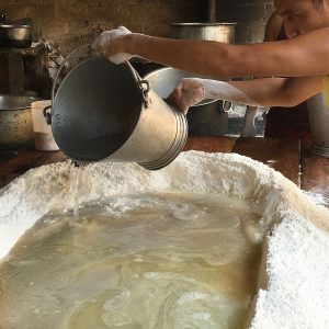 pouring boiling water into crater in pile of flour