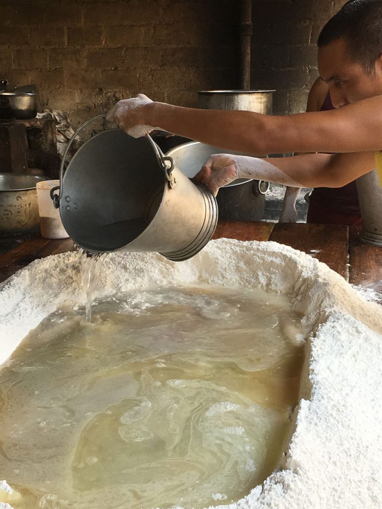 pouring boiling water into crater in pile of flour